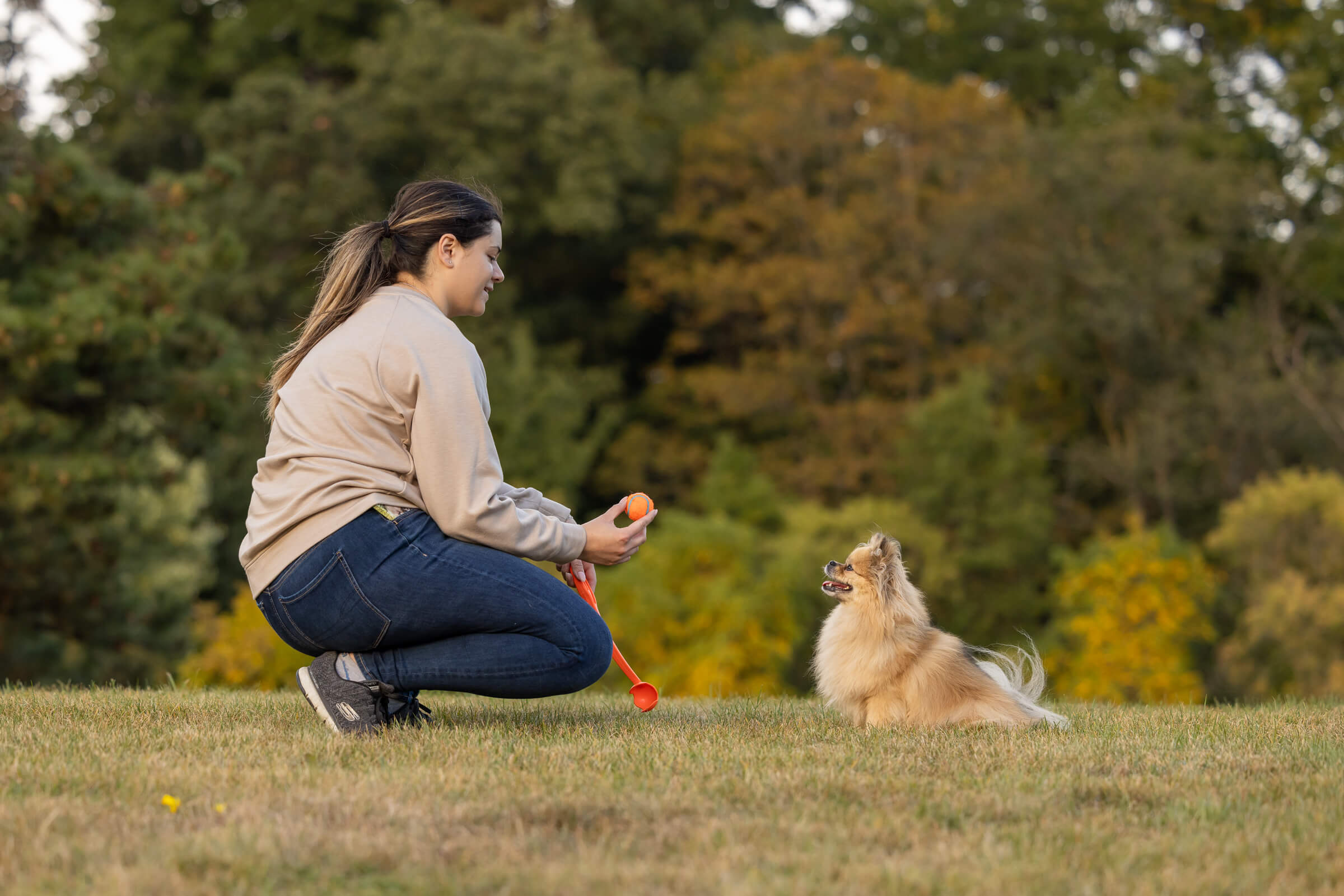 young woman with dog playing with chuck it ball