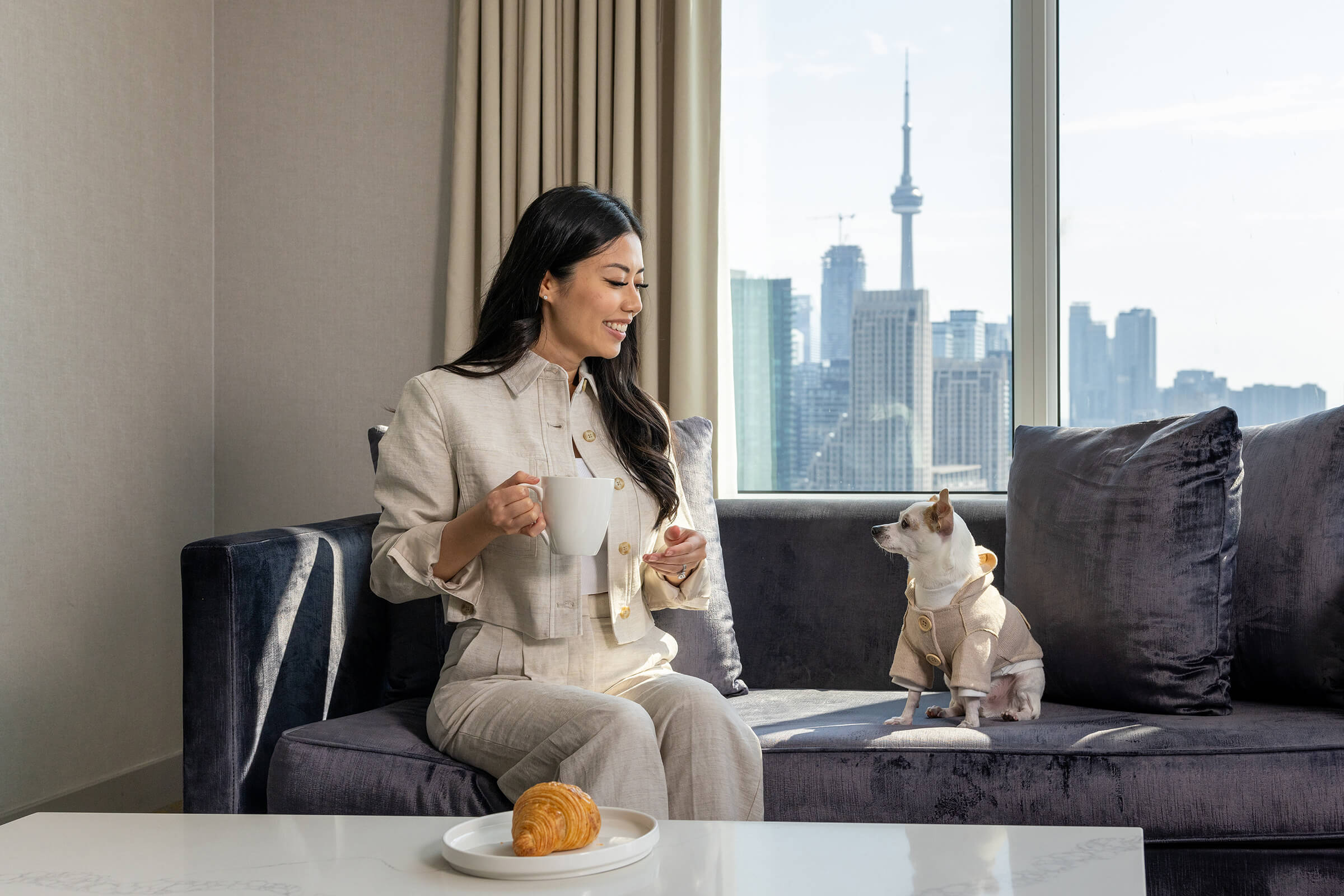 woman enjoying coffee with her dog in a suite in Hotel X